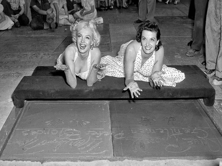 Marilyn Monroe and Jane Russell leave their handprints in the Forecourt of the Stars at Grauman's Chinese Theatre